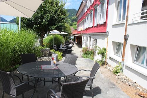 un patio avec une table et des chaises et un bâtiment dans l'établissement Hotel Sternen Unterwasser, à Unterwasser