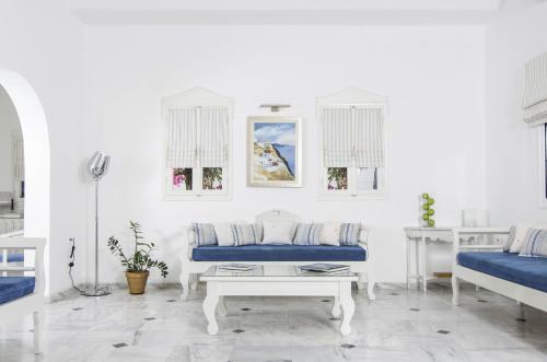 a white living room with a couch and a table at Paradise Resort in Akrotiri