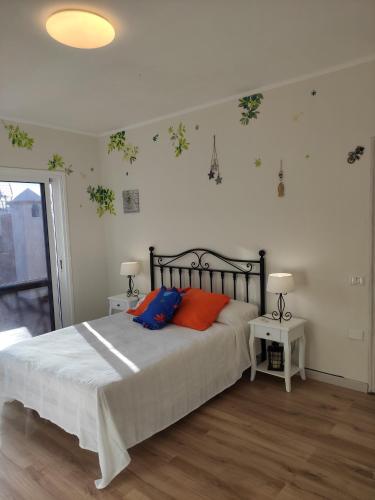 1 dormitorio con 1 cama con almohadas de color naranja y azul en La Casita del Sendero, en La Guancha