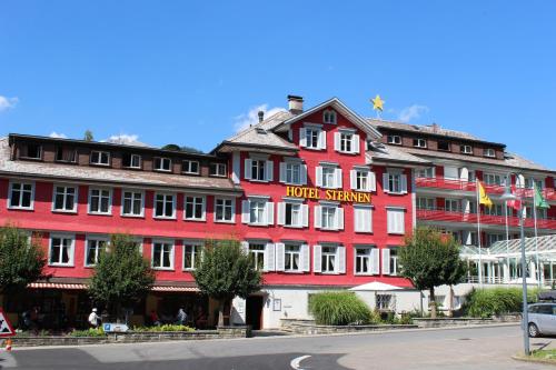 un gran edificio rojo con un cartel en él en Hotel Sternen Unterwasser, en Unterwasser