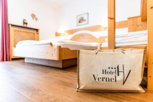 a bag sitting on the floor in a room with two beds at Hotel Vernel in Santa Cristina in Val Gardena