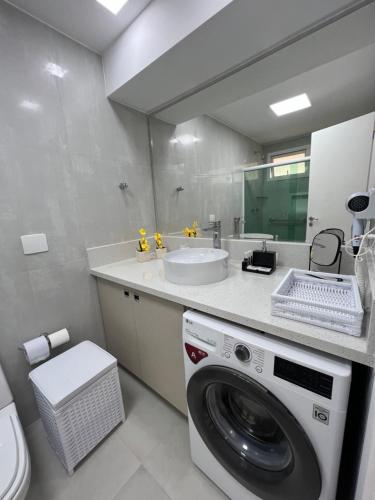 a bathroom with a washing machine and a sink at Buzios Beach Resort Residencial super luxo 1307 in Búzios