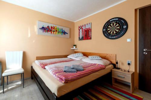 1 dormitorio con 1 cama y reloj en la pared en Cozy room at metro station, private bathroom, 9minutes oldtown, 15minutes airport, WiFi, en Praga