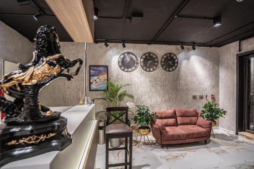 a living room with a couch and clocks on the wall at Diamond Hotel in Amman