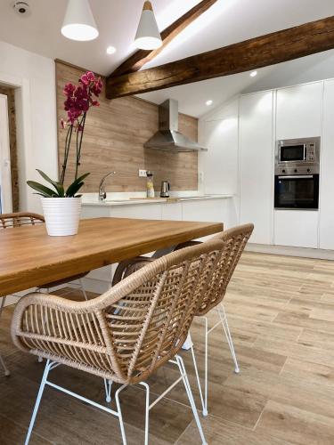 a kitchen with a wooden table and chairs at Celanova House in Celanova
