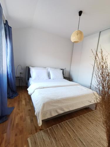 Schlafzimmer mit einem Bett mit weißer Bettwäsche in der Unterkunft Forest 88 apartment in Mostar