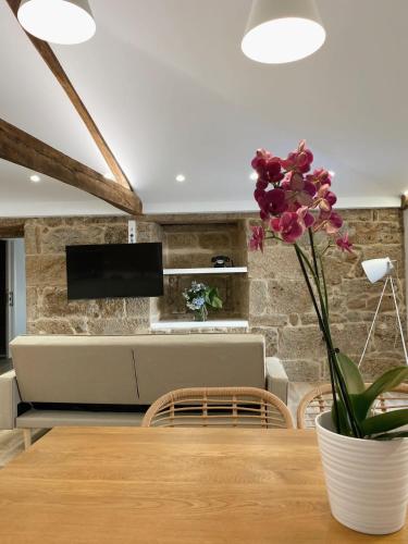 a dining room with a table with a vase of flowers at Celanova House in Celanova