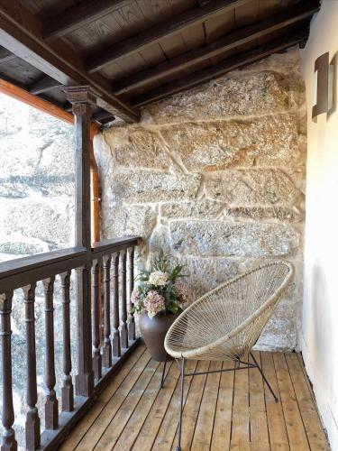 a chair sitting on a porch with a plant at Celanova House in Celanova