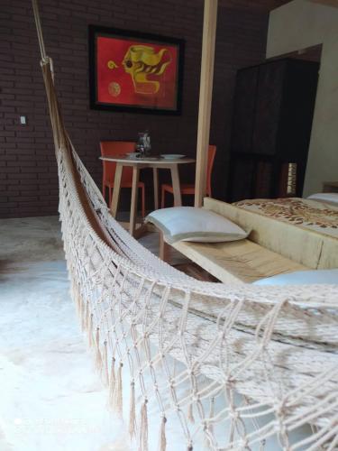 a white rope hammock in a room with a table at Hotel Bendita Luna in Mazunte