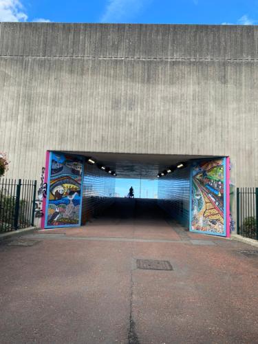 a large building with paintings on the side of it at Lovely New 2 Bedroom Condo with Stunning Seaviews in Penmaen-mawr