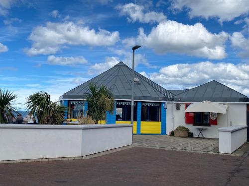 a restaurant with a yellow and blue building at Lovely New 2 Bedroom Condo with Stunning Seaviews in Penmaen-mawr