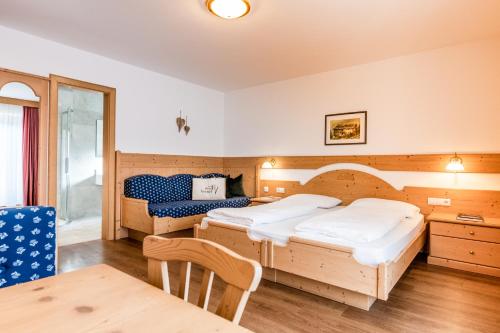 a hotel room with two beds and a table at Hotel Vernel in Santa Cristina in Val Gardena