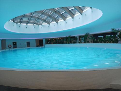 a large swimming pool in a building with a ceiling at Luksusowy apartament z widokiem, basenem i sauną Hanza Tower Szczecin in Szczecin
