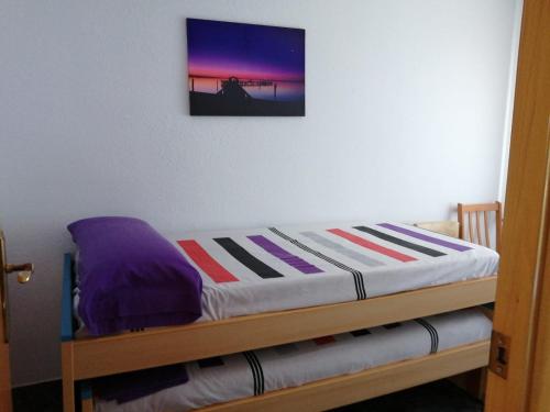 1 cama en una habitación con una foto en la pared en Apartamento Bella Carmen : para 6 personas, en Cunit