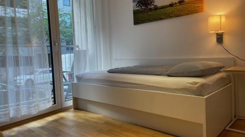 uma cama num quarto ao lado de uma janela em Myroom Business Apartment Nähe Messe München em Munique