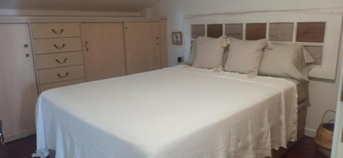 een slaapkamer met een groot bed met een witte sprei bij Ático acogedor en casco antiguo in Cangas de Morrazo