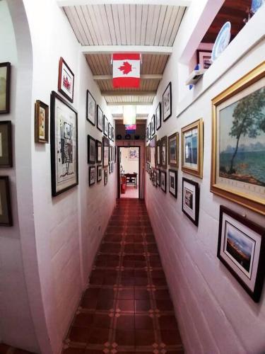 a hallway with paintings and pictures on the walls at Casa de la colina in Santa Elena