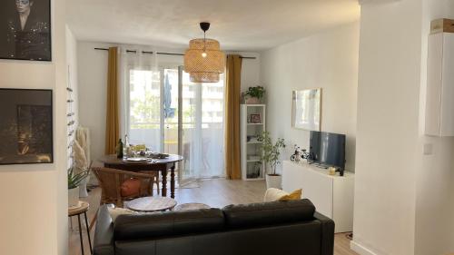 a living room with a black couch and a table at Large apartment near the beaches of Mourillon in Toulon
