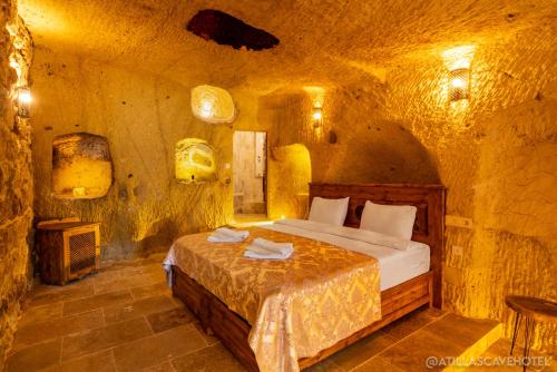 a bedroom with a bed in a stone room at Atilla's Cave Hotel in Nevsehir