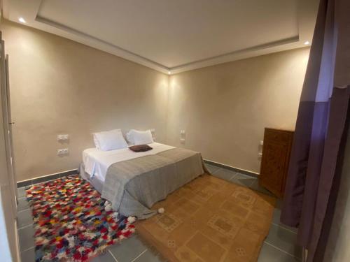 a bedroom with a bed and a rug at Villa Diaf Johanne in Aït Ourir