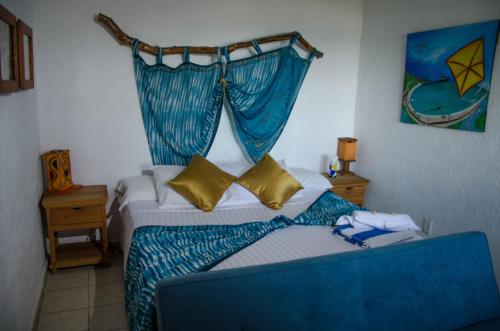 a bedroom with a bed with a blue canopy at Hotel Gilda in Coyuca