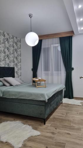 a bedroom with a bed with a table on it at Apartman Ivkovic in Sremska Mitrovica