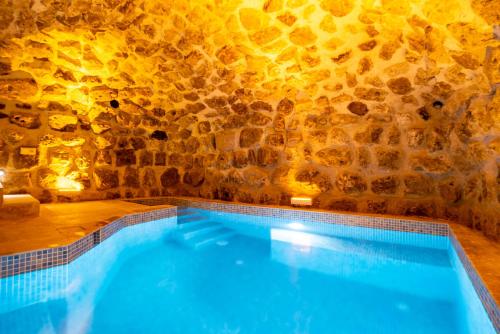 a swimming pool in a cave with a stone wall at Atilla's Cave Hotel in Nevsehir