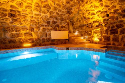 a swimming pool in a cave with a stone wall at Atilla's Cave Hotel in Nevsehir