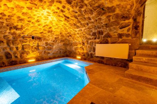 a swimming pool in a room with a stone wall at Atilla's Cave Hotel in Nevsehir