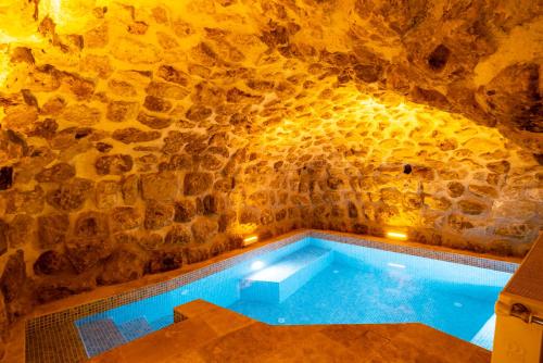 a swimming pool in a cave with a stone wall at Atilla's Cave Hotel in Nevsehir