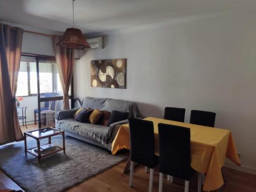 a living room with a couch and a table at Caparica Apartment near beach in Costa da Caparica