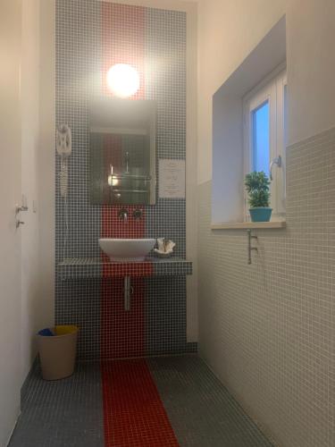 a bathroom with a sink, toilet and mirror at Nuova Mastrarua Rooms in Syracuse