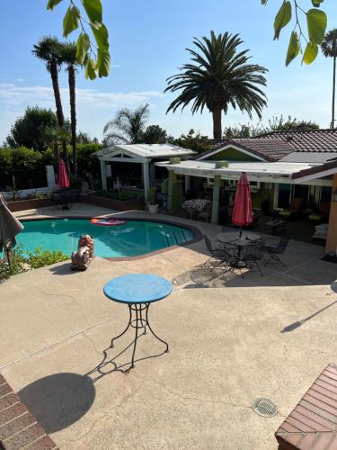 un patio con mesa, sillas y piscina en Beautiful Foothill Living, en Rancho Cucamonga