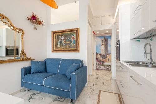 einen blauen Stuhl im Wohnzimmer mit Spiegel in der Unterkunft Suite La Fenice in Bergamo