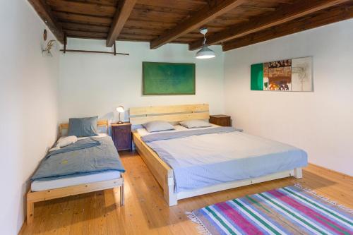 2 camas en un dormitorio con techos de madera y suelo de madera en Romantická chalúpka na polosamote, en Plavecký Svätý Peter