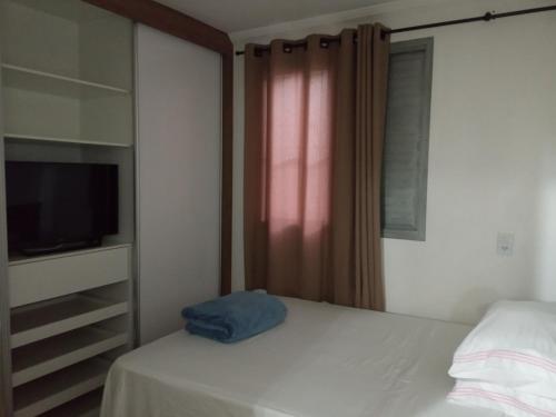 a bedroom with a bed and a tv and a window at The Flat 15 in Campinas