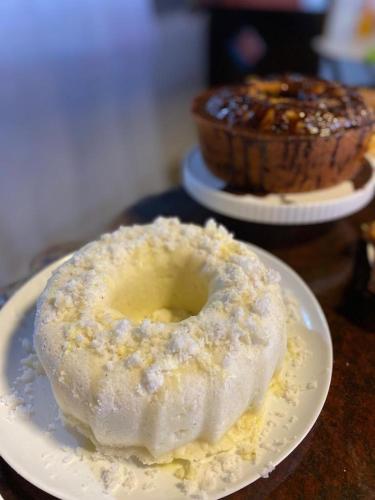 a doughnut on a plate with a cake on a table at Pousada da praça in Morro de São Paulo