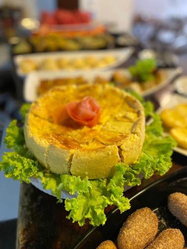 a sandwich with a tomato and lettuce on a table at Pousada da praça in Morro de São Paulo