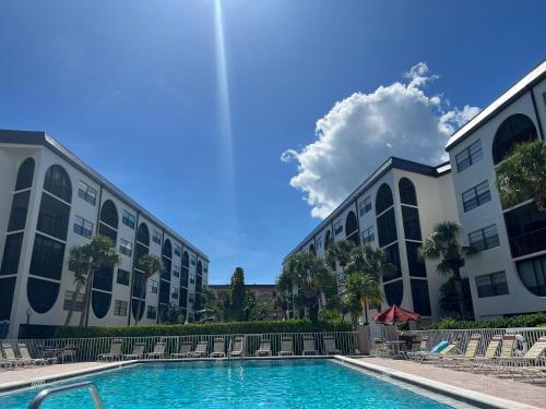 a swimming pool in front of two buildings at Knot a Care Remodeled Direct water access condo with ocean and pool views NOW SLEEPS SIX in Marco Island