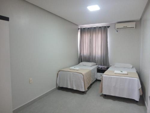 a hospital room with two beds and a window at Hotel Solar Vitória in Vitória da Conquista