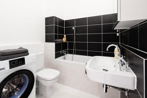 La salle de bains est pourvue d'un lavabo, de toilettes et d'un lave-linge. dans l'établissement Project Comfort Apartament Dywizjonu 303 175/8 Warszawa, à Varsovie