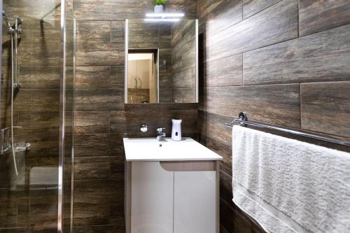 a bathroom with a sink and a mirror and a shower at Scorpio Apartman/Sobe in Palić