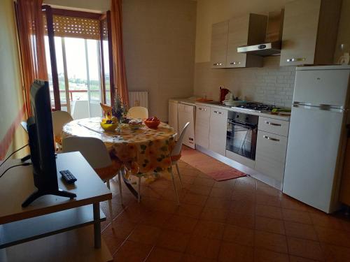 a kitchen with a table and a kitchen with a television at Gioiamare in Martinsicuro