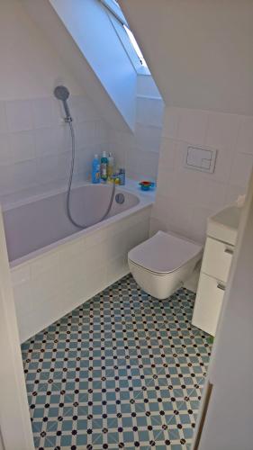 a bathroom with a tub and a toilet and a sink at Błękitny domek in Darłowo
