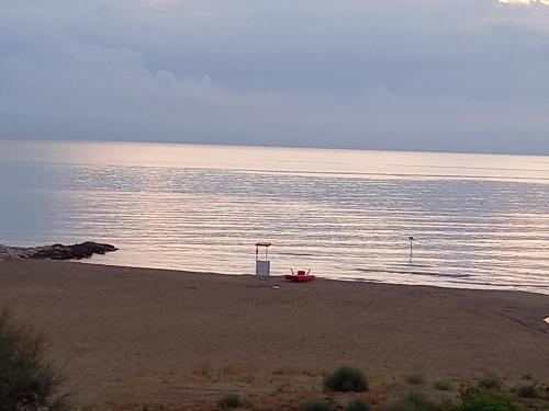 a beach with a red boat in the water at Gioiamare in Martinsicuro
