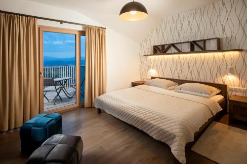 a bedroom with a large bed and a balcony at Hillside Y41 in Dolný Kubín