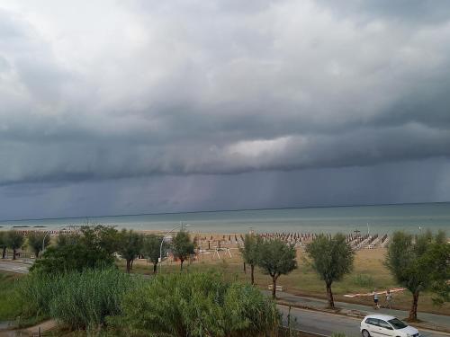 a view of the ocean and a cloudy sky with a car at Gioiamare in Martinsicuro