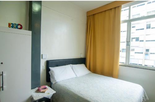 1 dormitorio con cama y ventana grande en Studio lindo, en Río de Janeiro