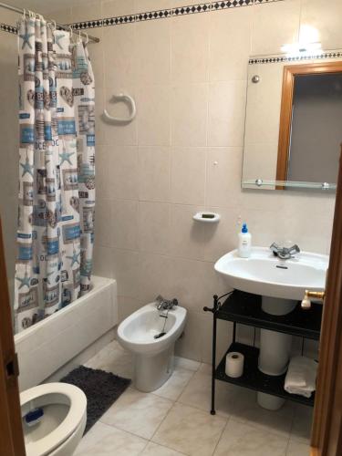 y baño con lavabo, aseo y cortina de ducha. en Precioso apartamento en Urbanización junto al mar. en Alicante