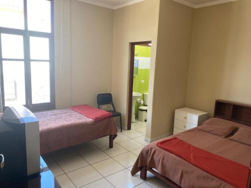 a bedroom with two beds and a mirror at Dpto Bolivar Hermoso, amplio y bien ubicado en la chura Tarija in Tarija